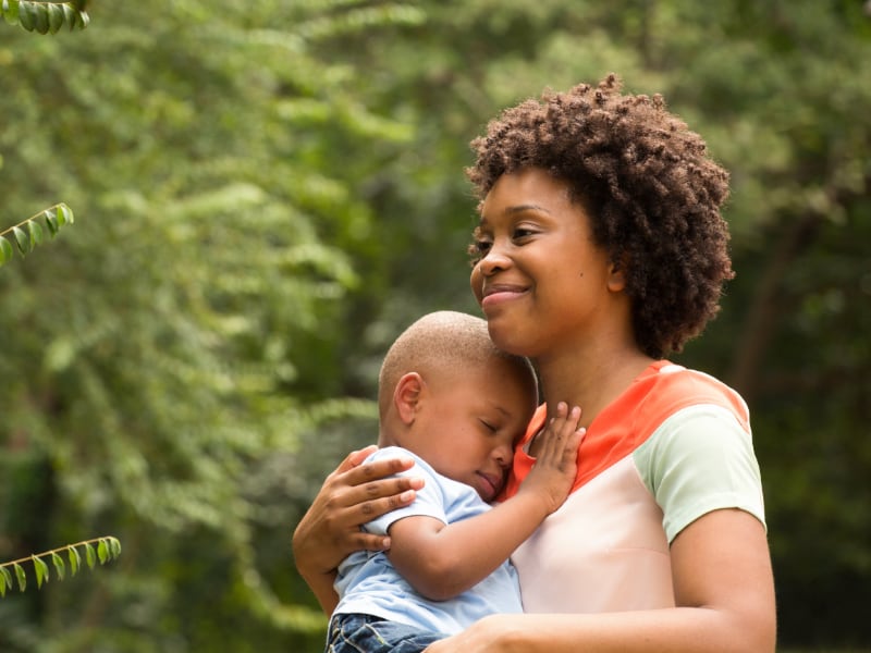 A Black mother holds her infant close to her