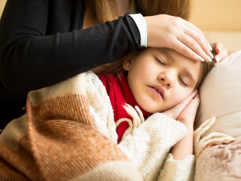 A mother checks her child's temperature