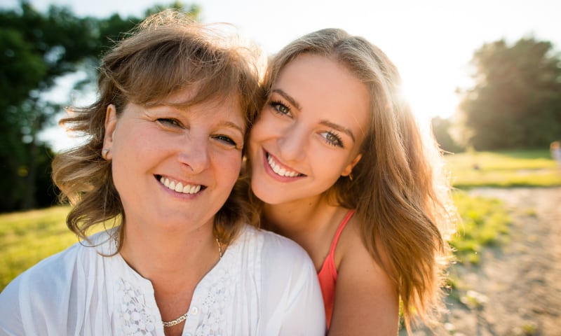 A smiling mother and teen daughter